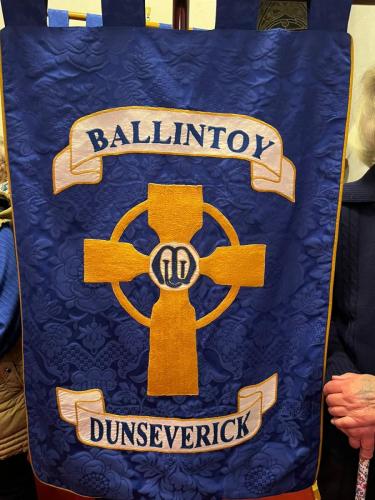 The other side of the banner depicts the cross and MU logo .